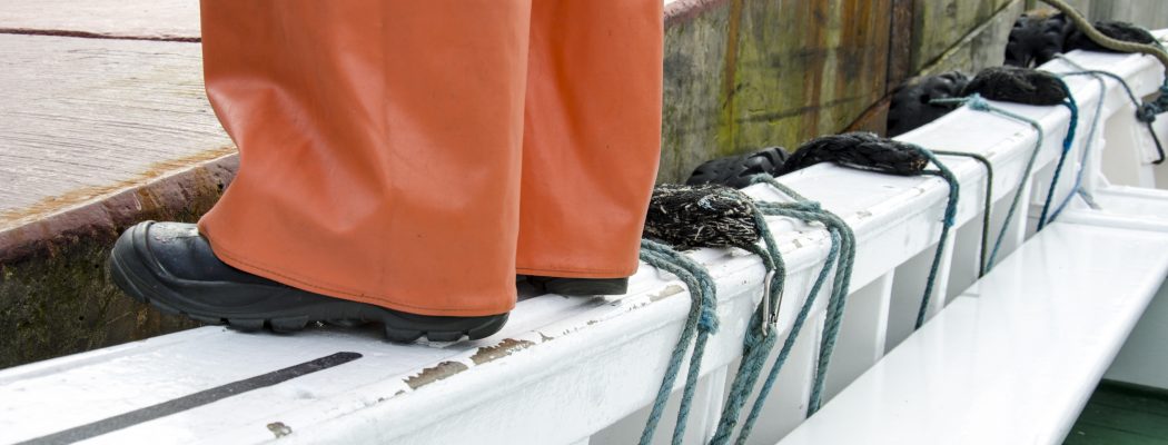 person stand up in the edge of a boat
