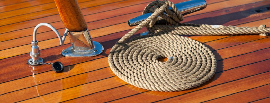 Rope neatly coiled on the wooden deck of a boat.