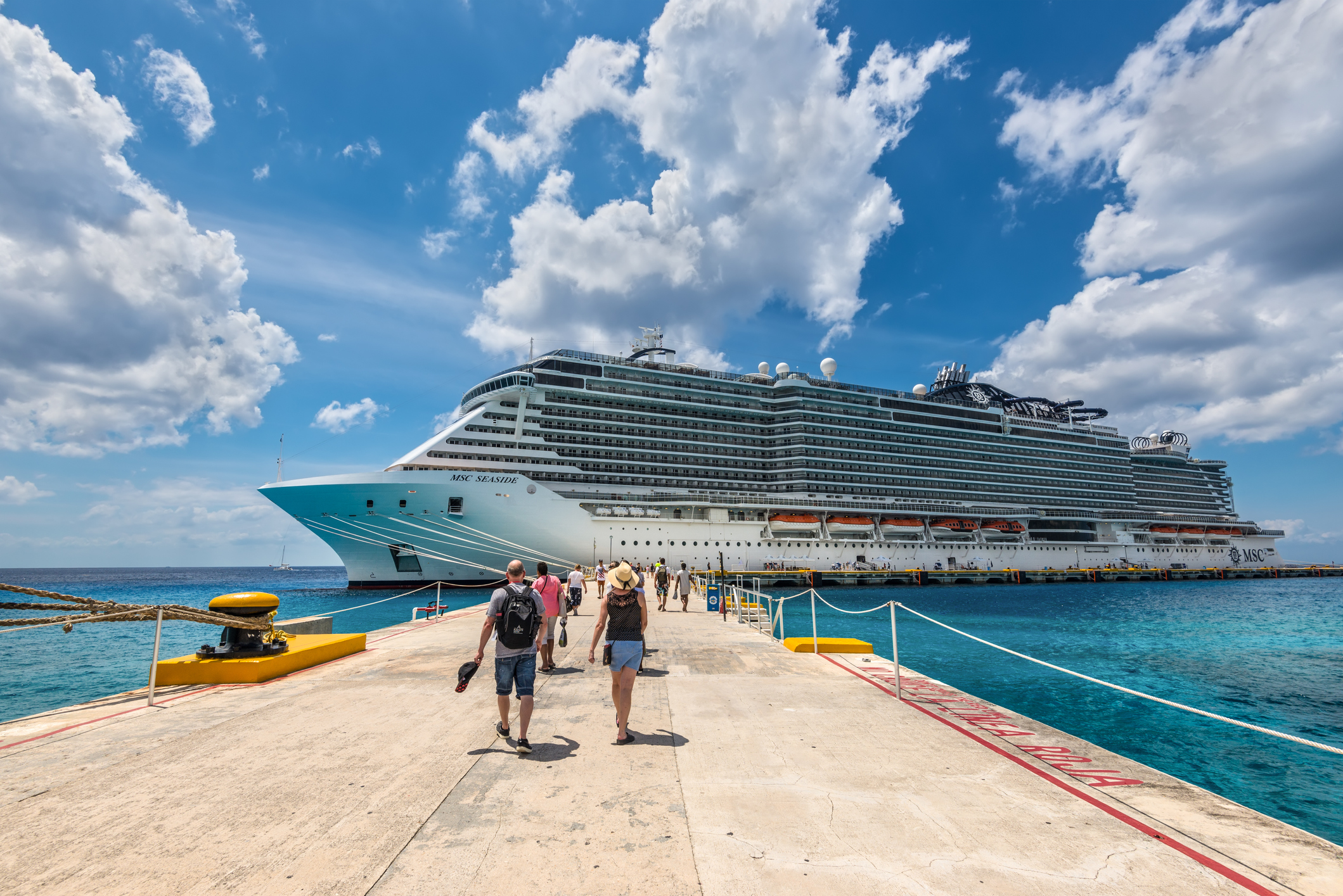 Cruise passengers arrive to the cruise ship to check in and board the MSC Seaside Cruise Ship which sails from Cozumel to Miami.