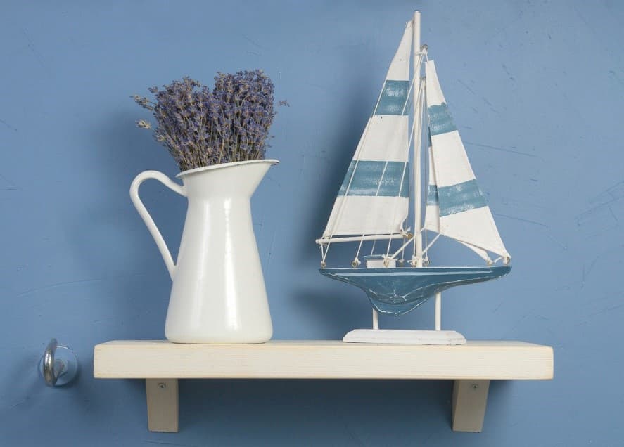 A white pitcher and a blue and white sailboat