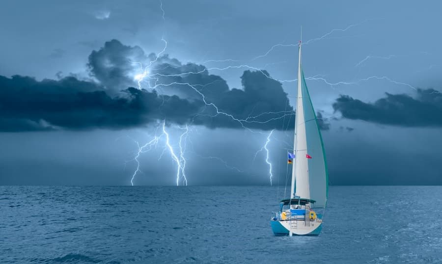 A sailboat in the water with lightning