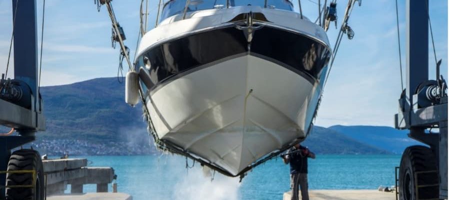 A person standing on a dock holding a boat
